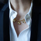 Collier Sphère à pampilles boules dorées porté au creux d’un col de chemise ouvert